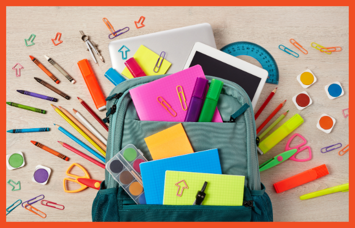 Photo of a backpack filled with children's school supplies, including crayons, paint, scissors, notebooks, a laptop, a tablet, and more.