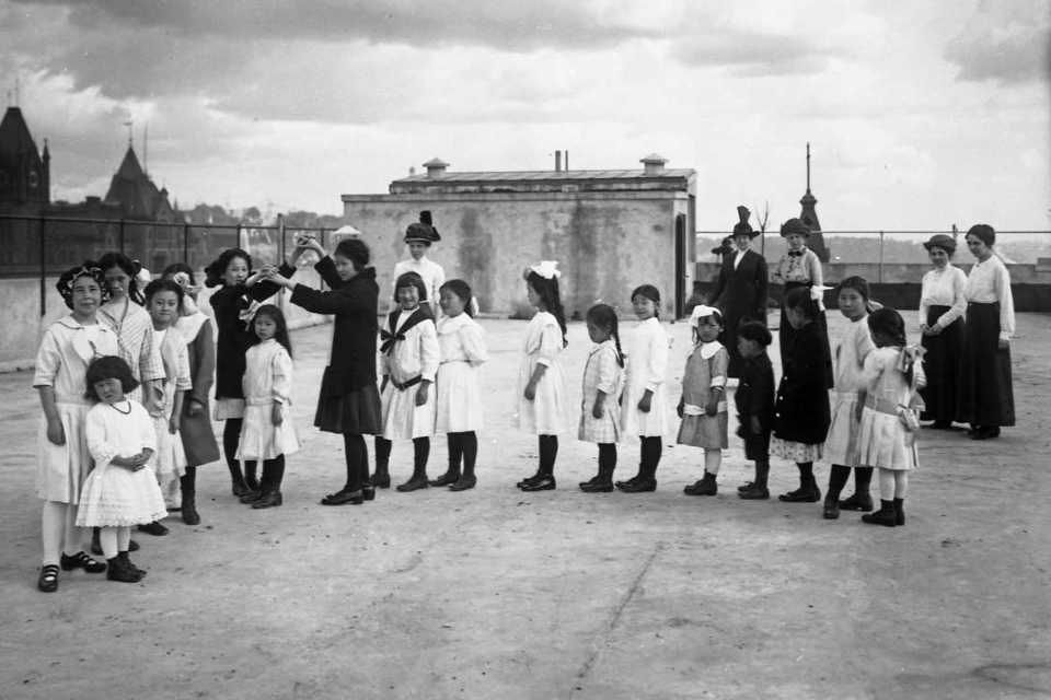 A black and white photo of AAPI children standing on top of a rooftop.