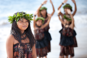 A photo of a Polynesian girl with four other dancers behind her